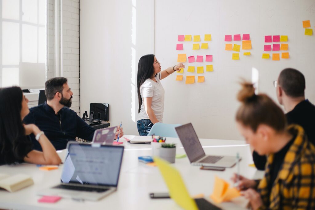 Consultants planning a project around a whiteboard